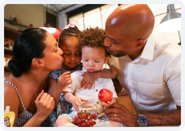 Family kissing baby