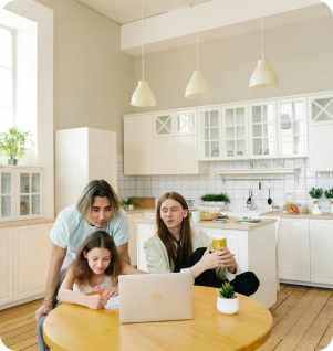 Parents help daughter with homework at kitchen table